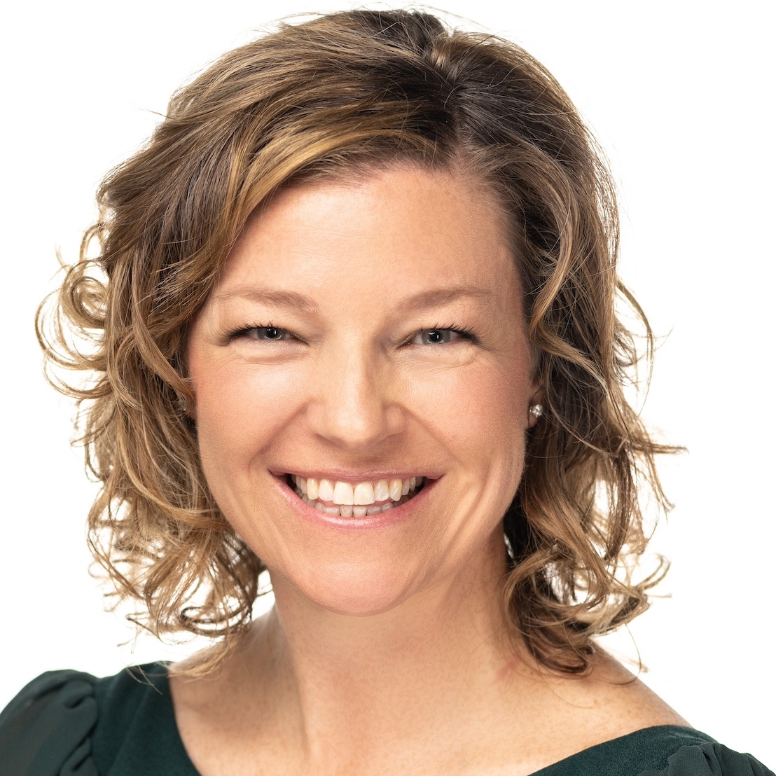 Fotografía de mujer sonriente con pelo rubio rizado hasta la barbilla sobre fondo blanco