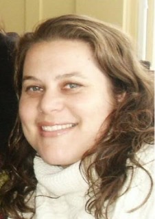 Head of smiling woman with shoulder length hair.