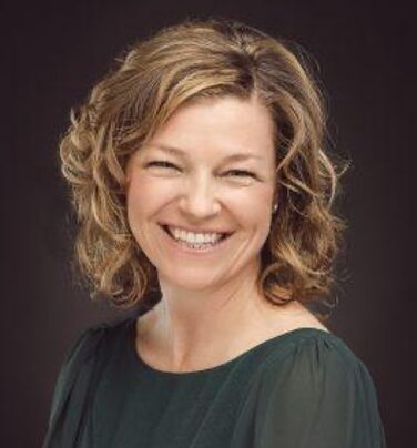 Smiling woman with curls in her hair.